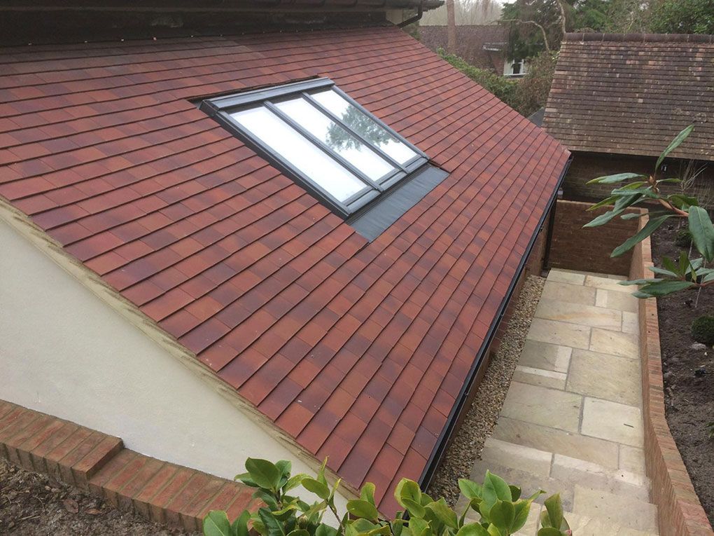A new clay-tiled roof with a skylight window fitted during a loft conversion